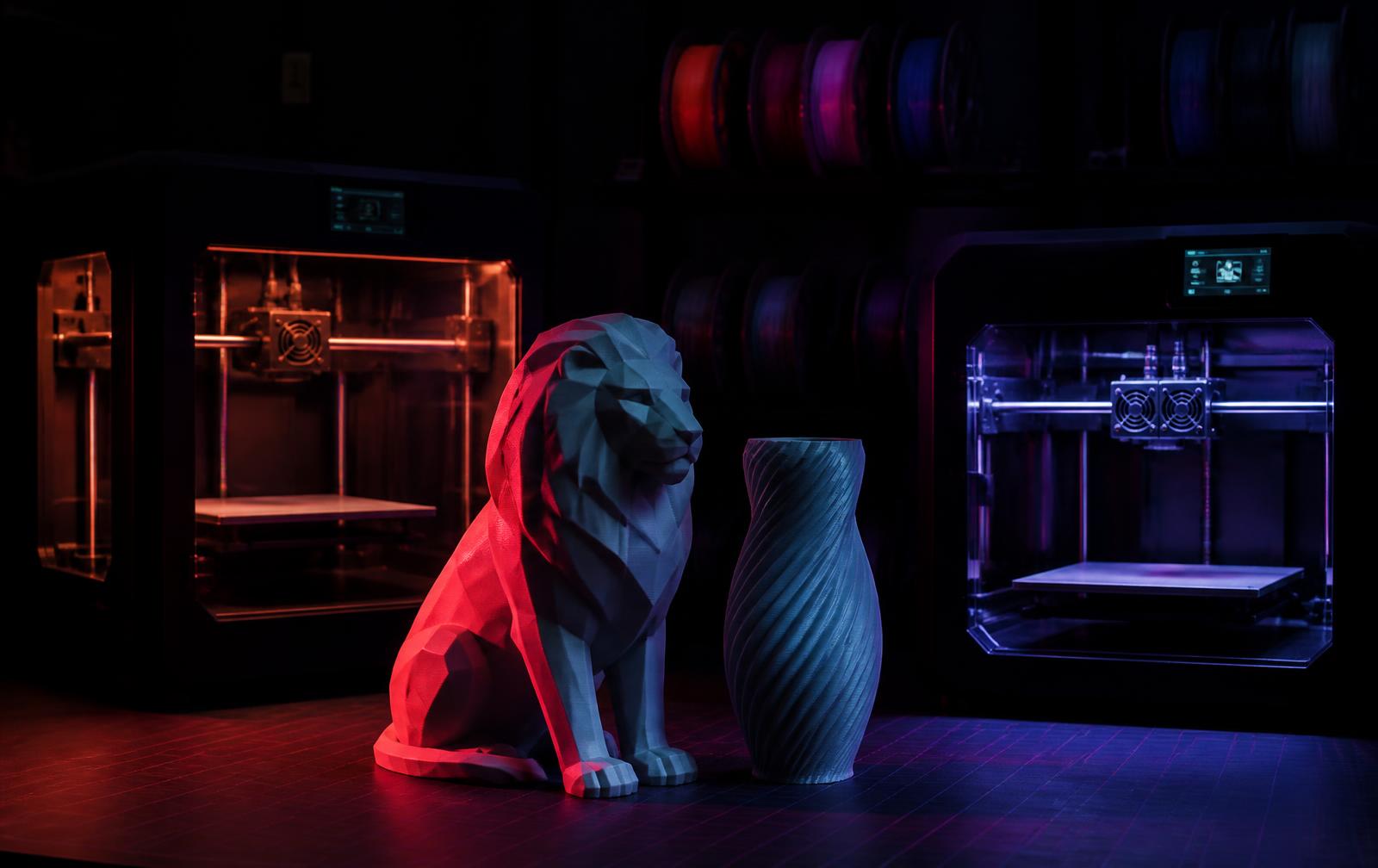 Bancada do ateliê T&M Lab com impressoras 3D em operação e peças acabadas